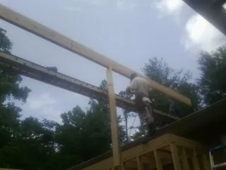 Carpenter setting a ridge beam over a new addition frame — Ice Dam Removal by Roofing Brothers in Garden Prairie