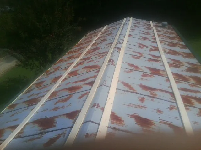 Rusted metal roof panels with new wood purlins before replacement — Storm Damage Roof Repair in Garden Prairie by Roofing Brothers