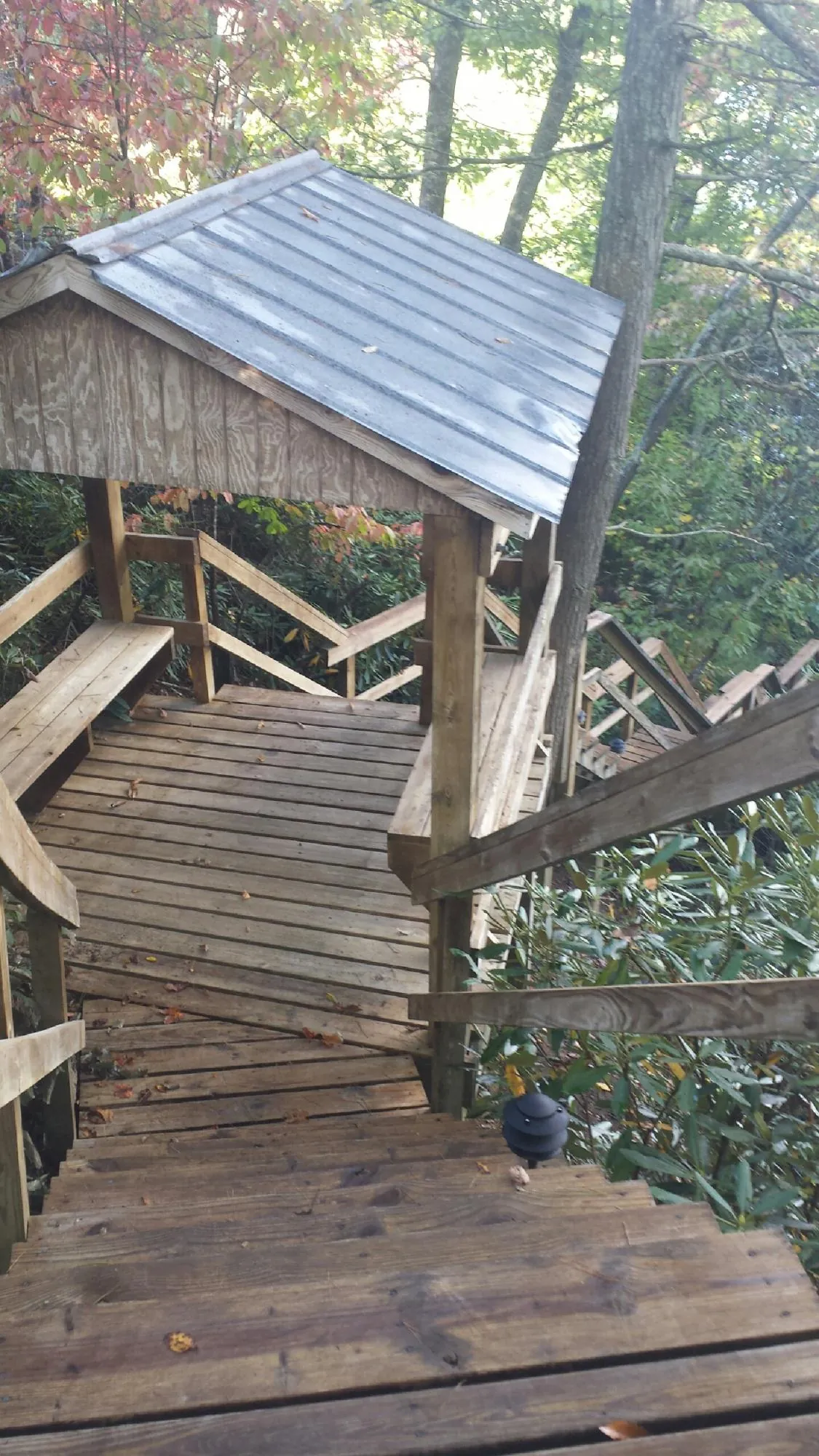 Metal roofed shelter over wooden steps on a wooded walkway — Skylight Repair & Installation work by our crew in Garden Prairie