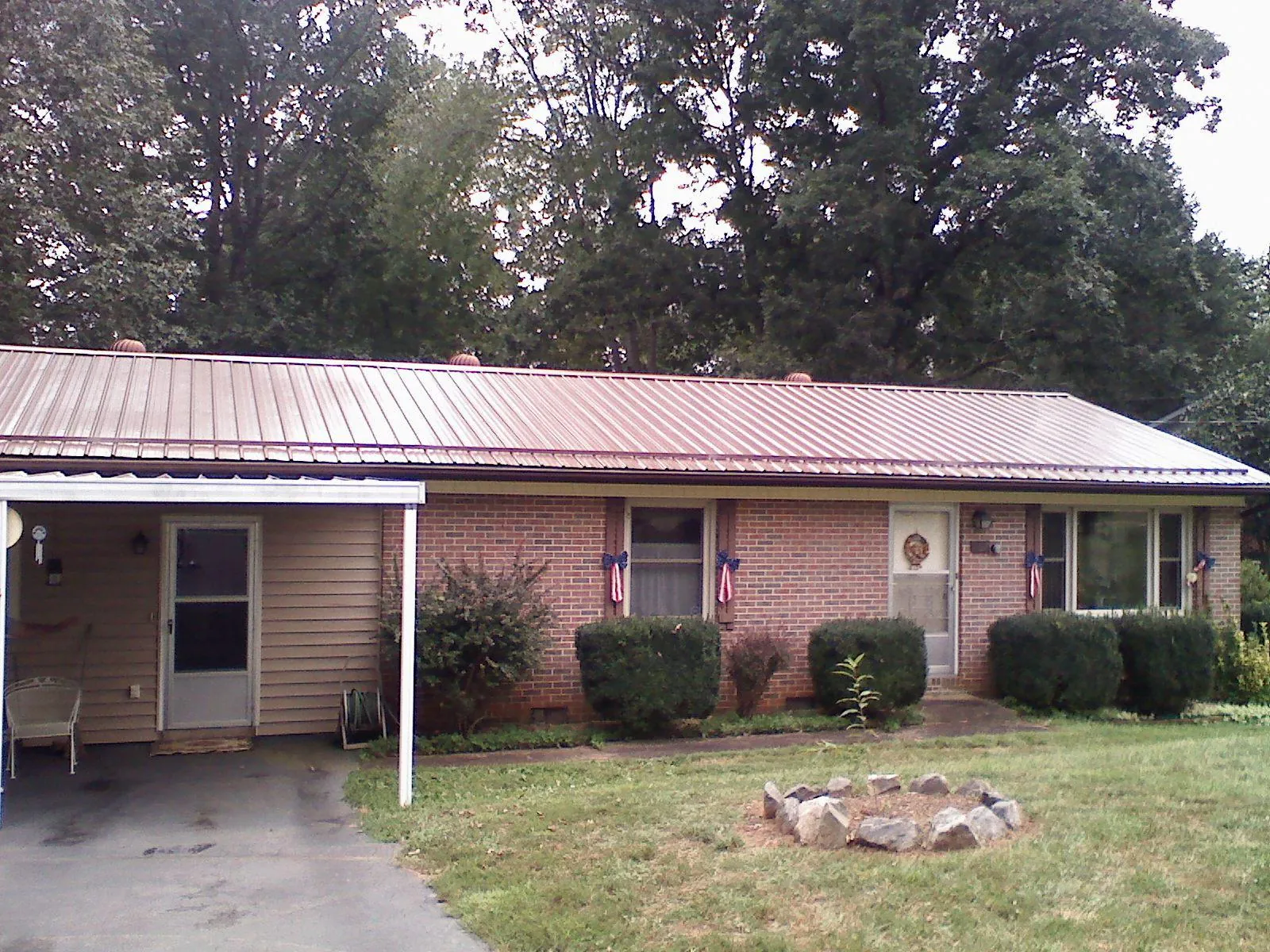 Bronze metal roof and carport on a brick ranch home — Roof Repair work by our crew in Garden Prairie